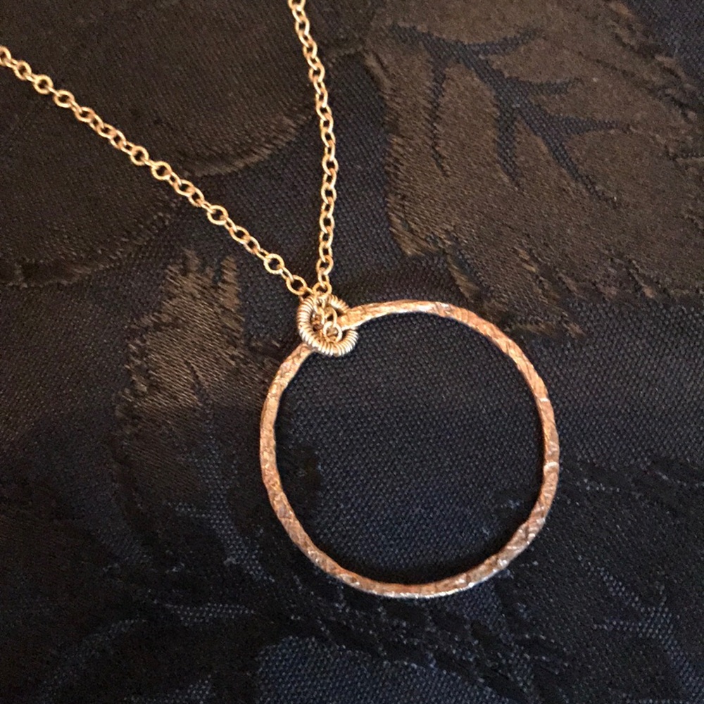Gold necklace with circle charm.